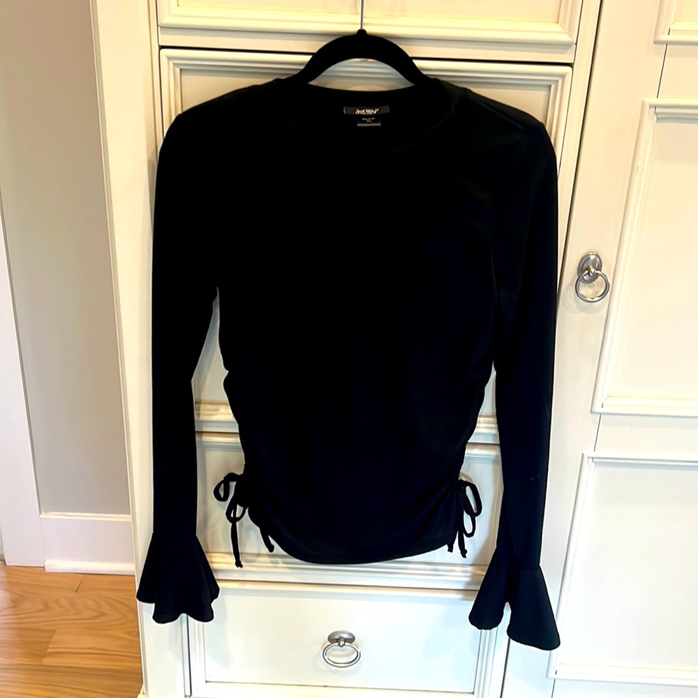 Black long sleeve top with bell bottom sleeves and size touching.